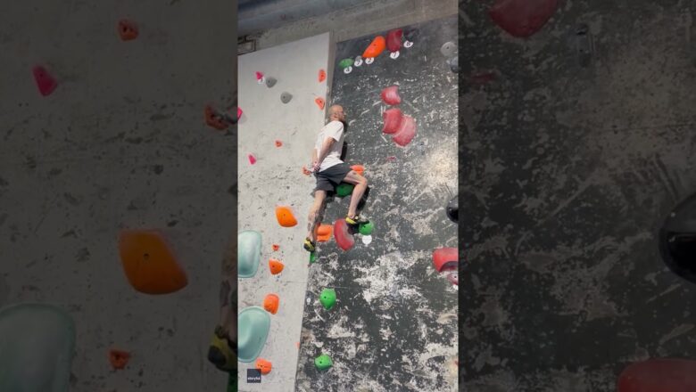 Climber scales rock wall with hands behind back #Shorts