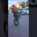 Man Rides Unicyle While Carrying Huge Bags
