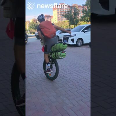 Man Rides Unicyle While Carrying Huge Bags