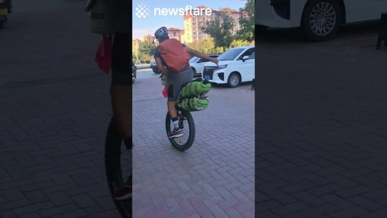 Man Rides Unicyle While Carrying Huge Bags